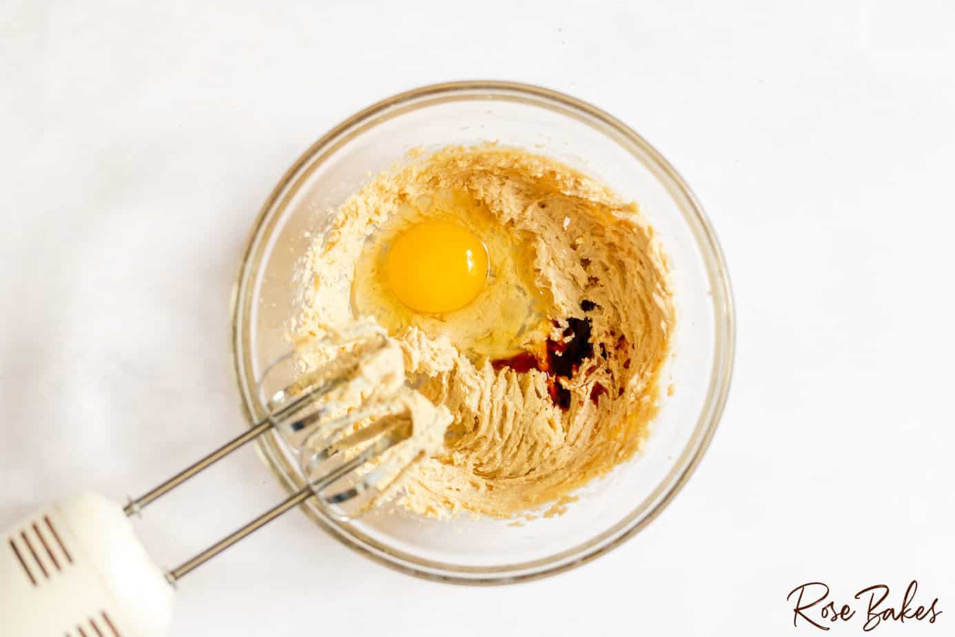 sugar and butter mixed with egg in bowl