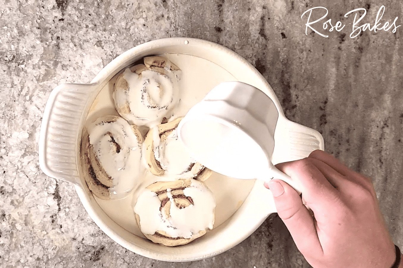 Heavy Cream being poured over the cinnamon rolls