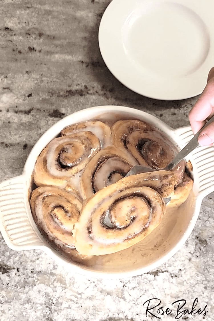 Cinnamon Rolls being lifted out of the pan with a serving spatula