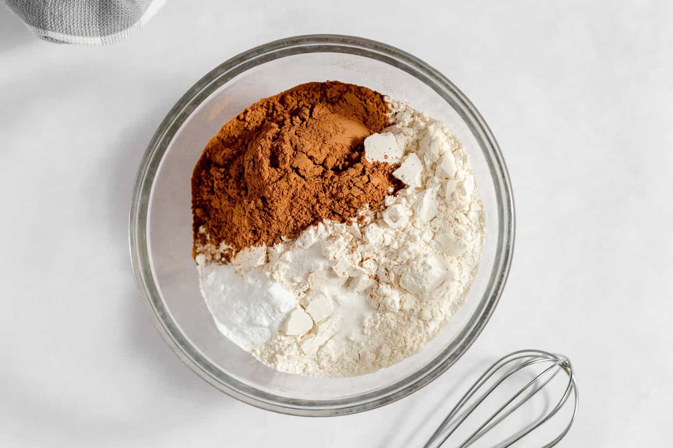 Dry ingredients added to a glass mixing bowl.