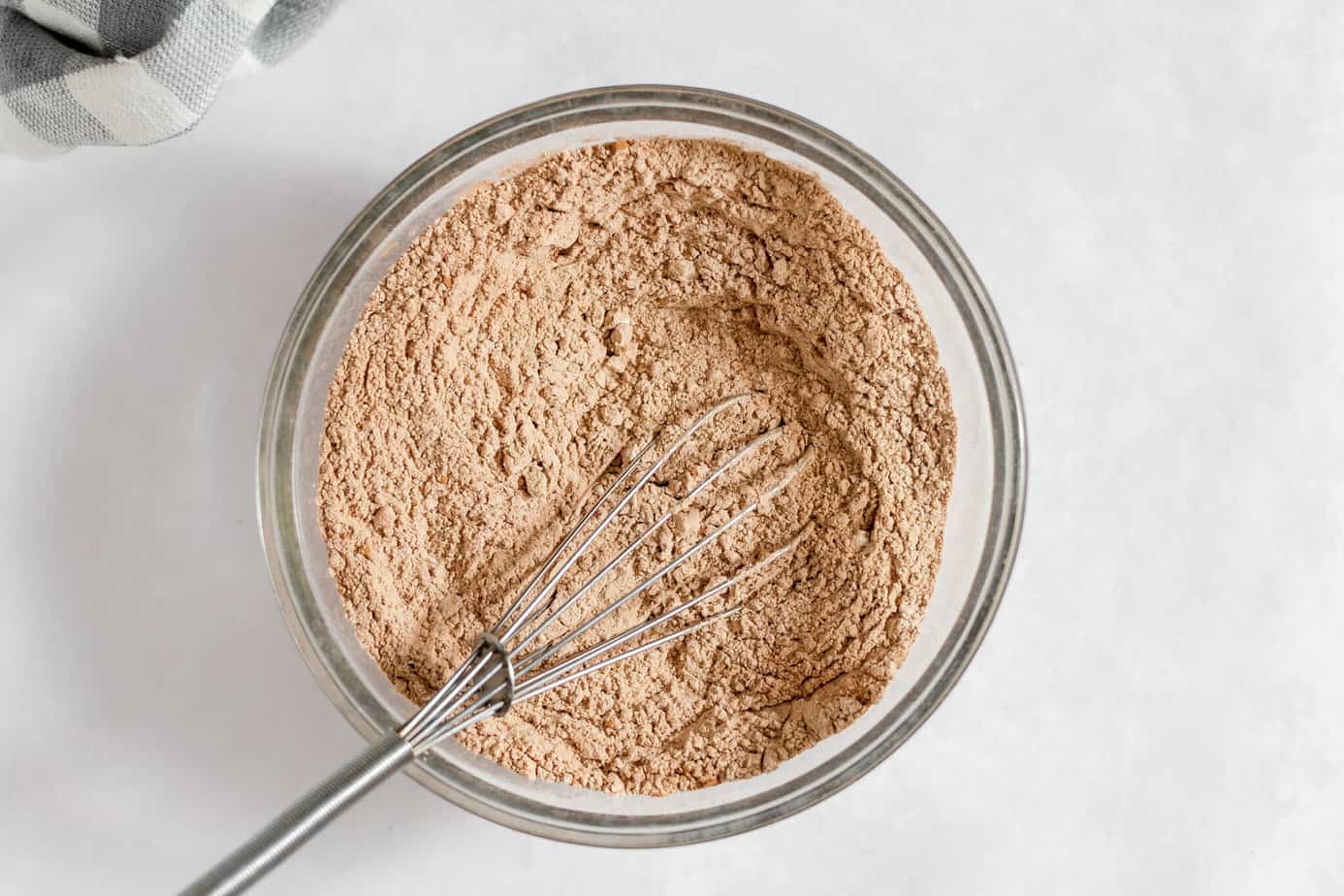 Dry ingredients whisked together in a glass mixing bowl.