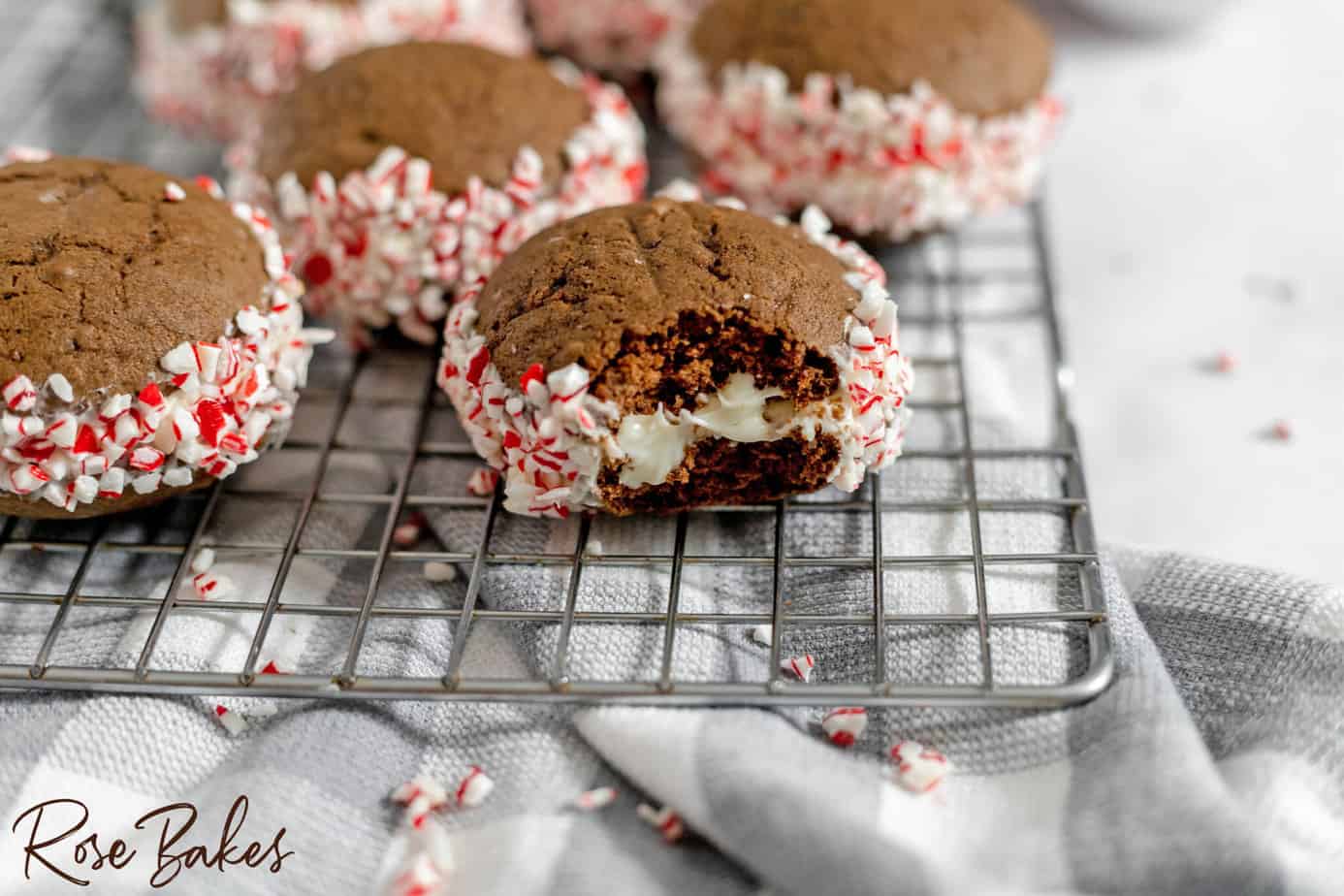 Whoopie pie on a wire rack with a bite taken out showing the buttercream filling.