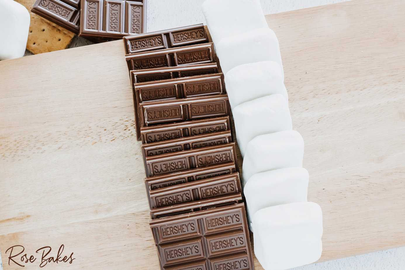 Add hershey's bars and square marshmallows to the center of the charcuterie board