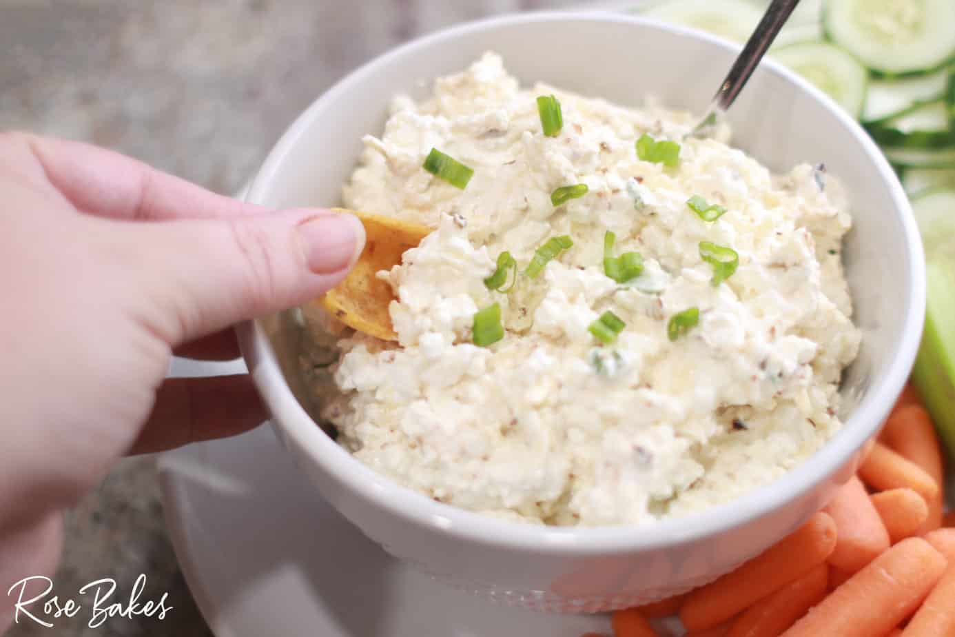 Hand taking a scoop of dip with a Frito Scoop.