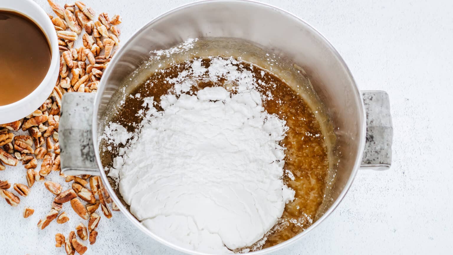 adding powdered sugar to praline candy mix in saucepan
