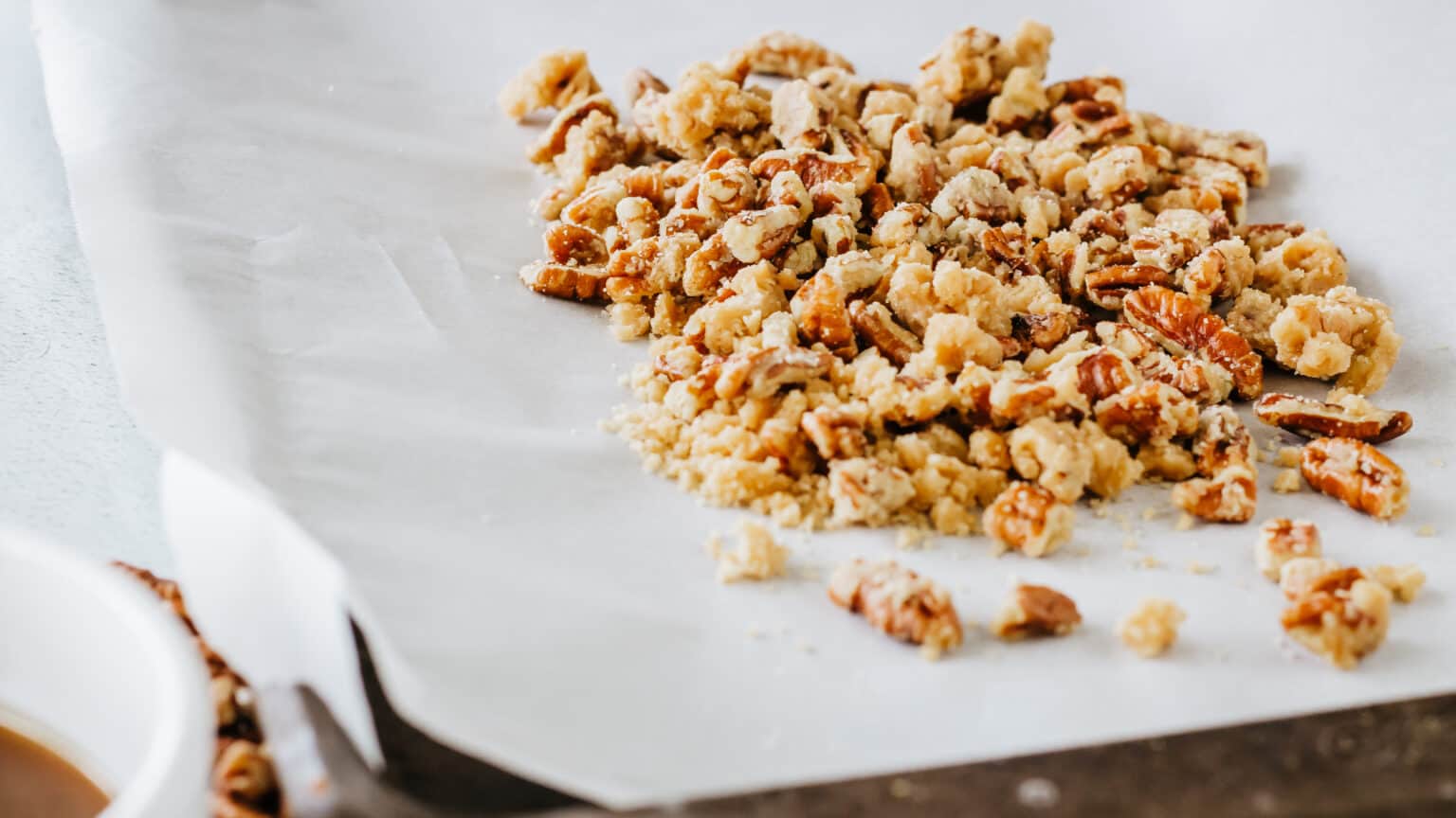 praline crunch topping on parchment paper on a cookie sheet