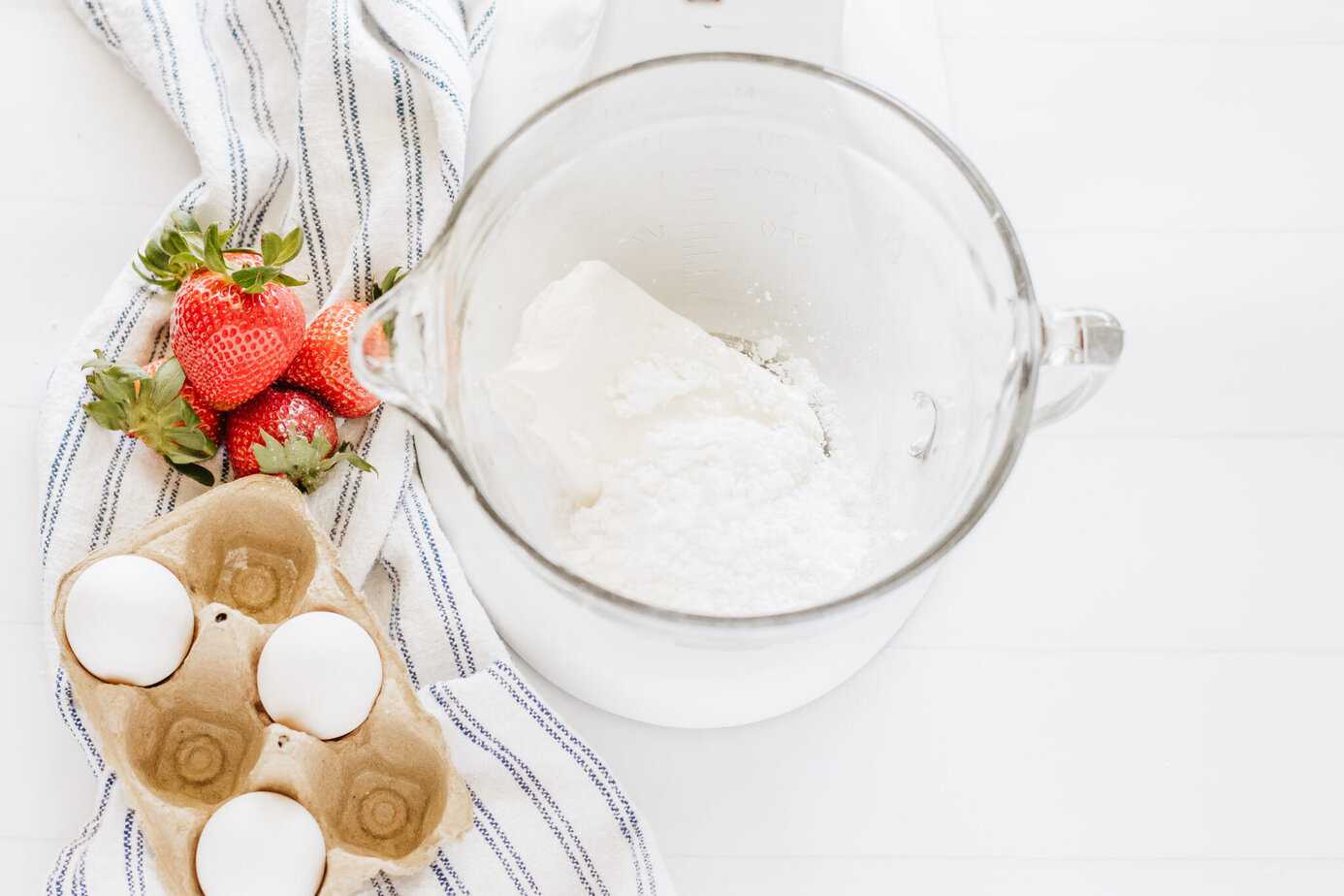 cream cheese and powdered sugar in a glas mixing bowl