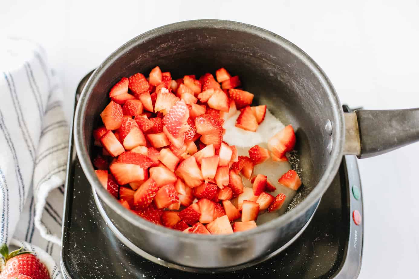 diced strawberries, sugar, lemon juice, vanilla in a boiler on a electric cooktop