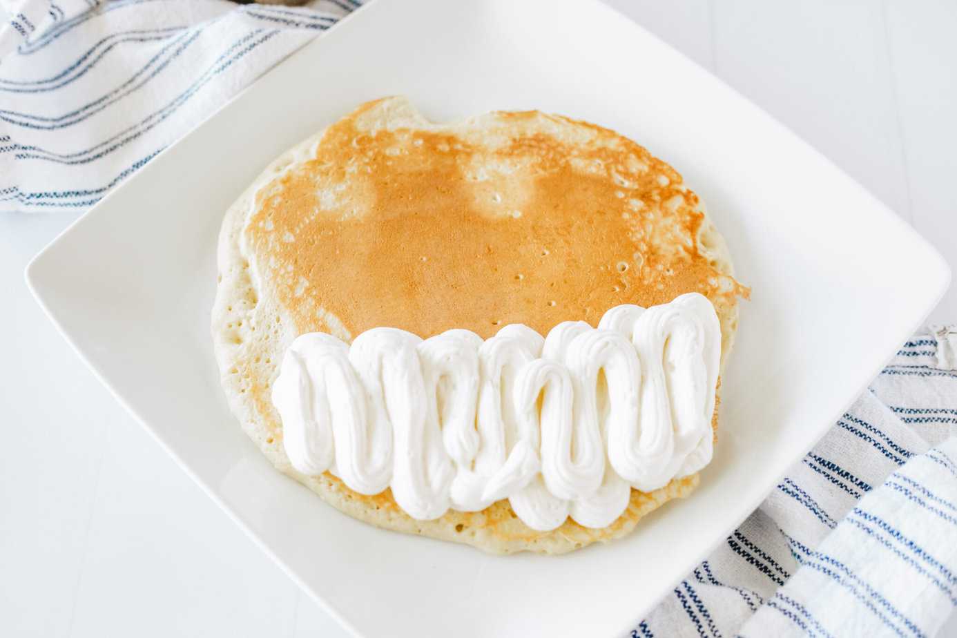 buttermilk pancake on a white plate with cheesecake mixture on half of it