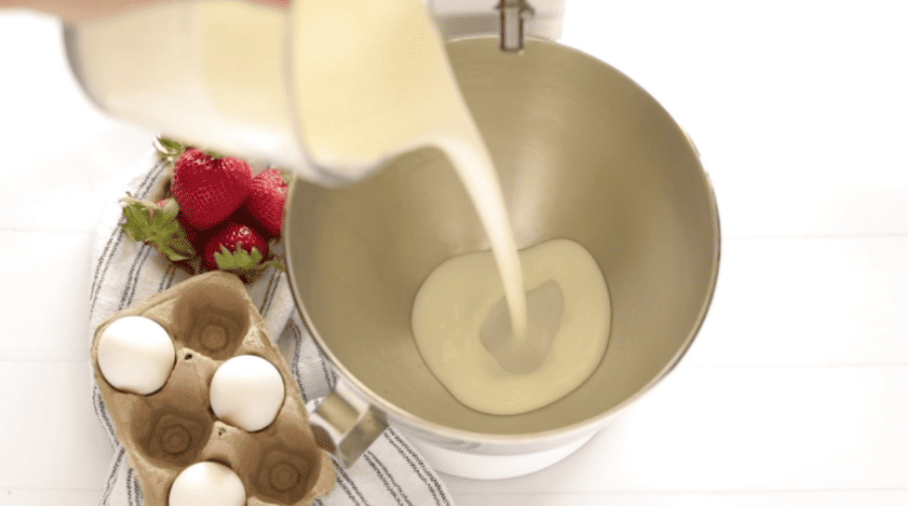 adding whipping cream to a mixing bowl