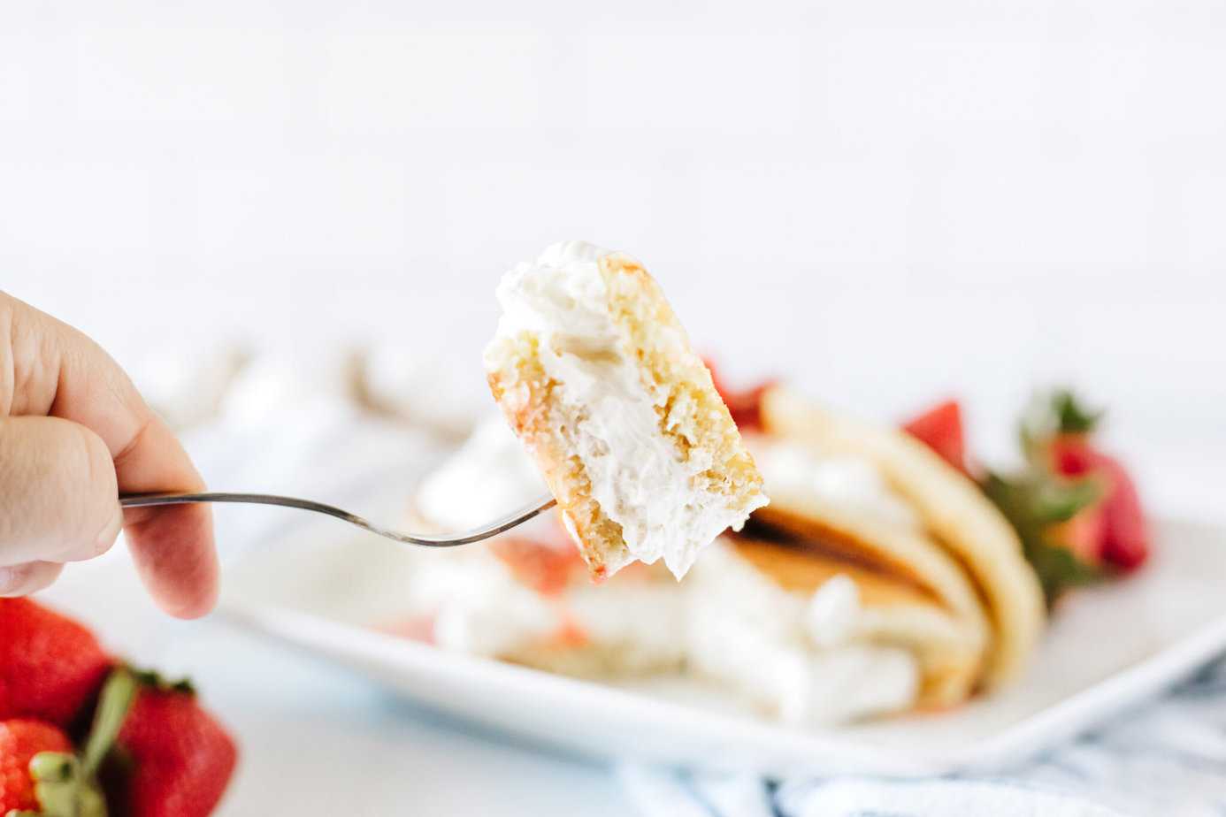 a bite of cheesecake stuffed pancakes on a fork