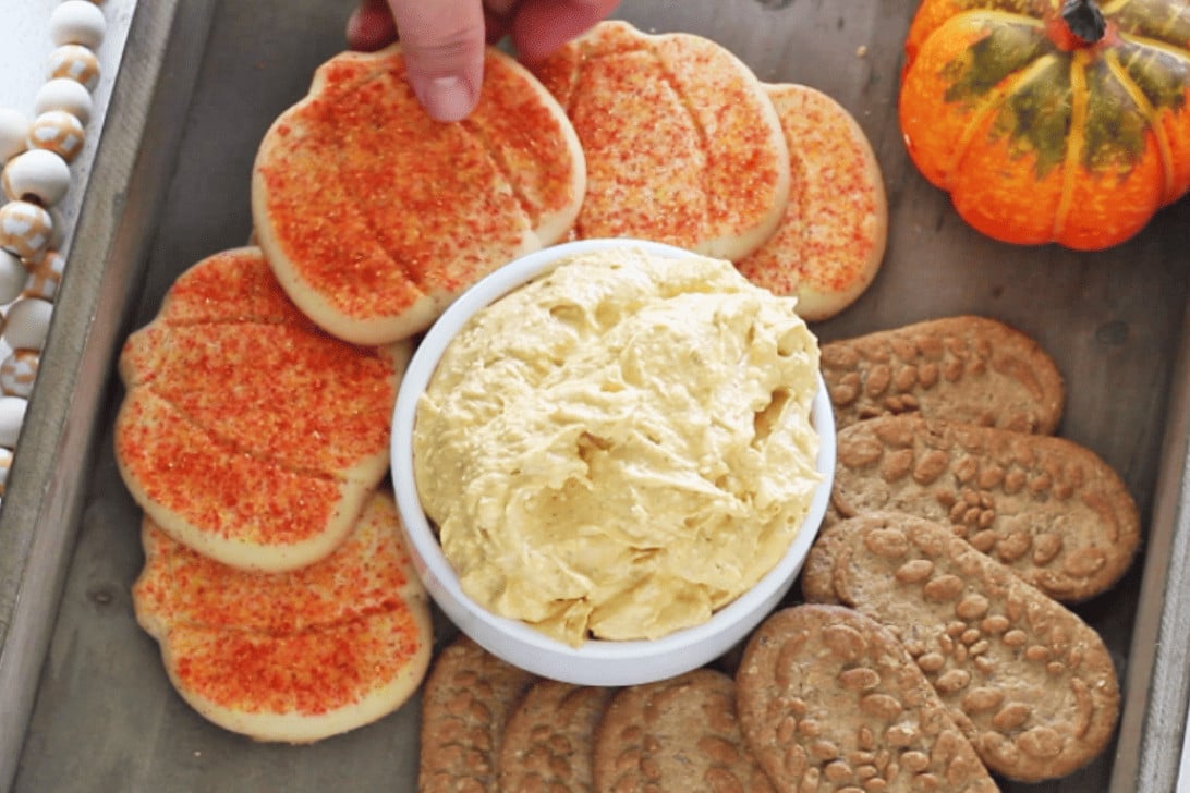 adding pumpkin shaped cookies around the dip
