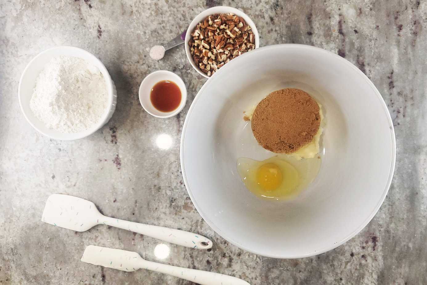 ingredients for Pecan Praline Cookies around a large white bowl with wet ingredients