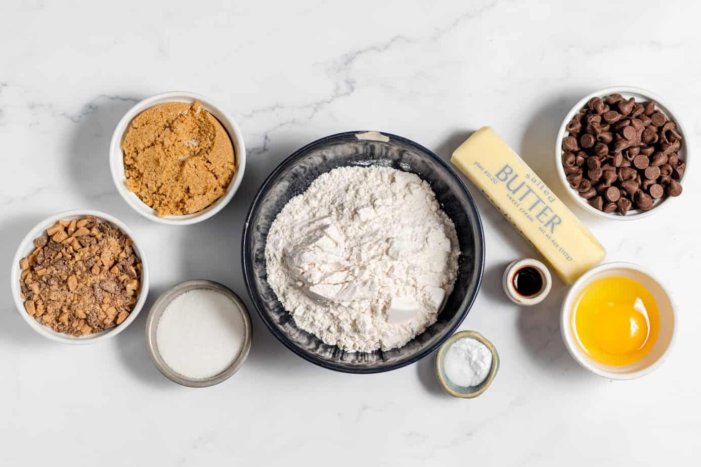 toffee chocolate chip cookie ingredients on a marble counter