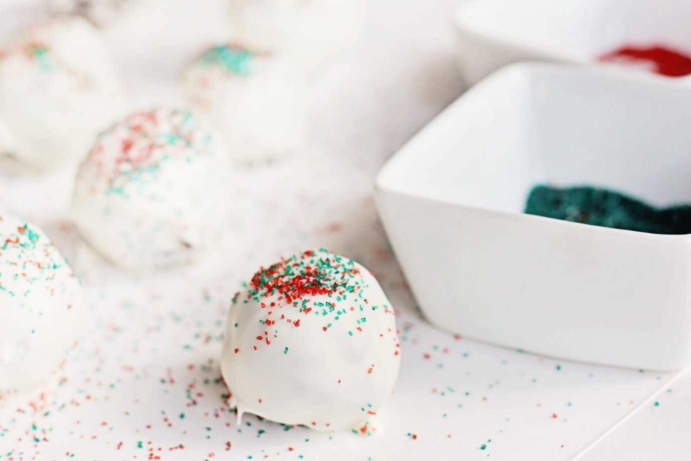 adding sprinkles to a Little Debbie Christmas Tree Cake Truffle