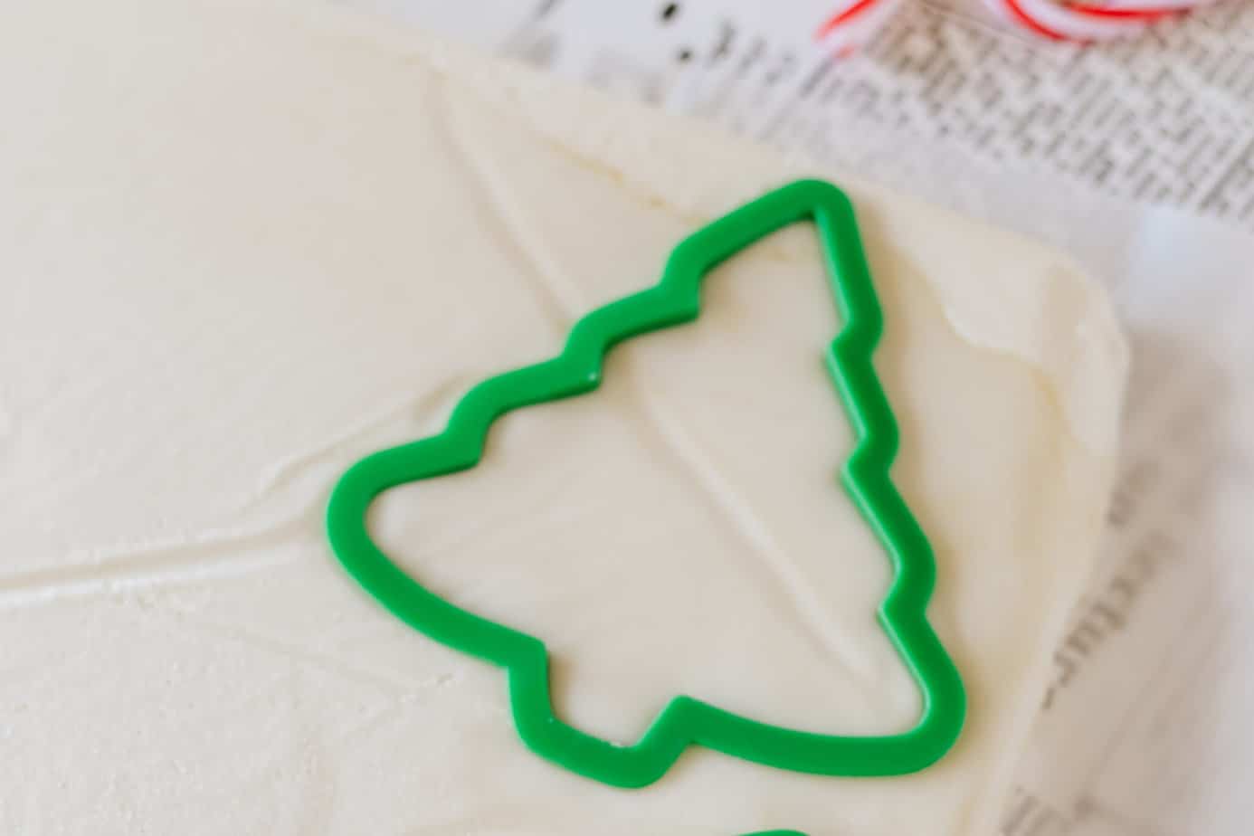christmas tree cookie cutter pressed into sheet of christmas fudge