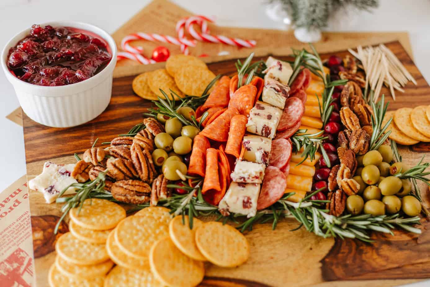 Christmas Charcuterie Board on cutting board with bowl of cranberry sauce