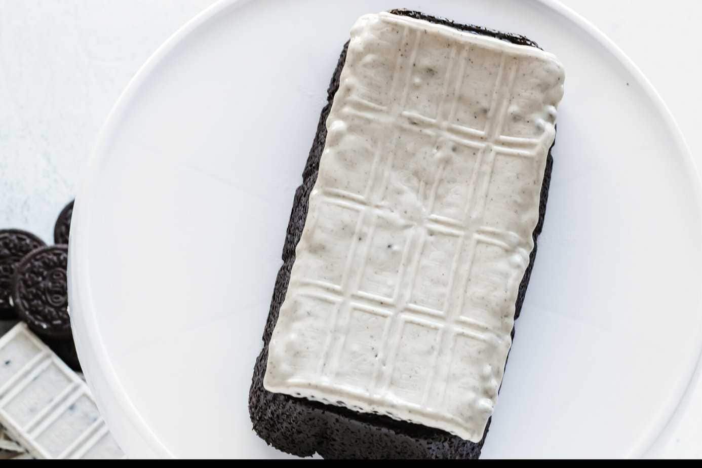 melted XL cookies & creme candy bar on top of 3 ingredient OREO Cake