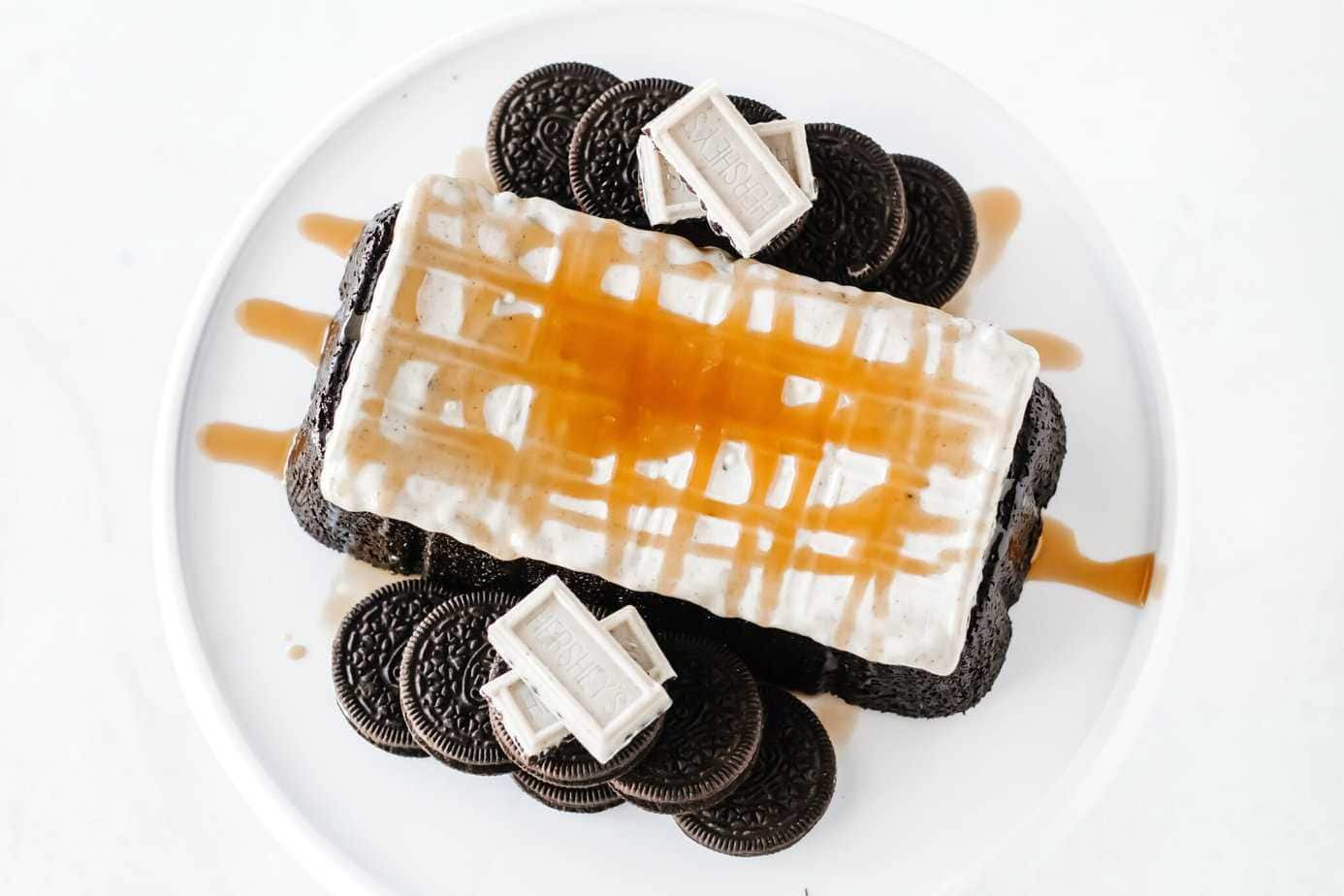 Simple OREO Cake recipe topped with white chocolate and caramel sauce