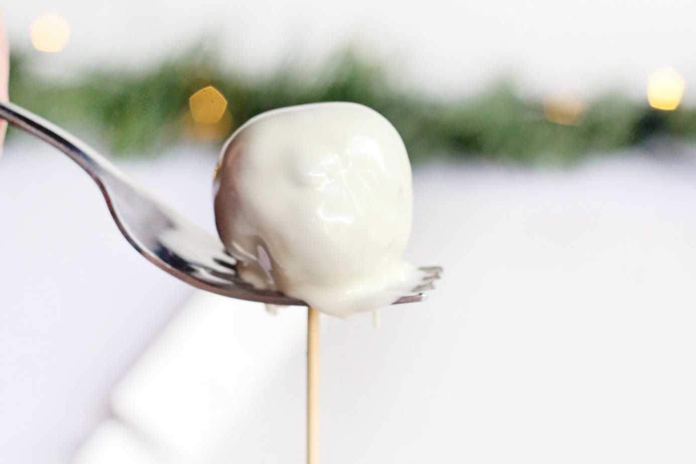 using a fork to remove a Little Debbie Christmas Tree Cake Truffle from the skewer
