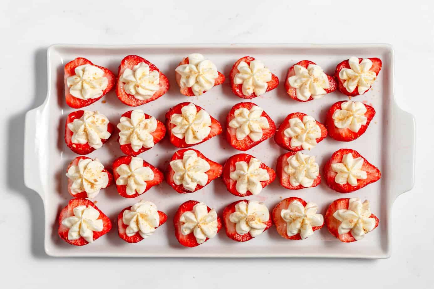 deviled strawberries lined up on a white platter