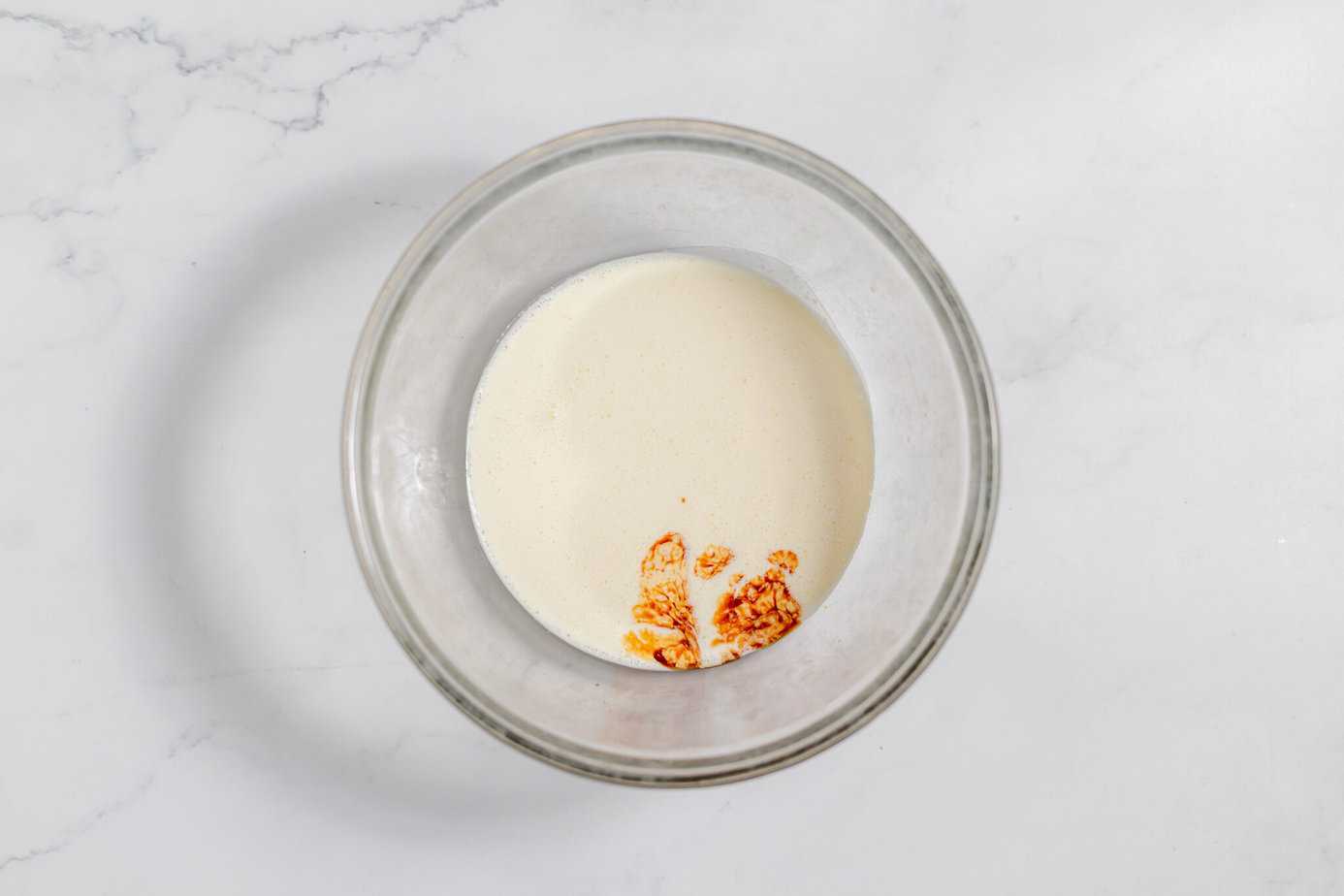 heavy whipping cream and vanilla in a clear bowl