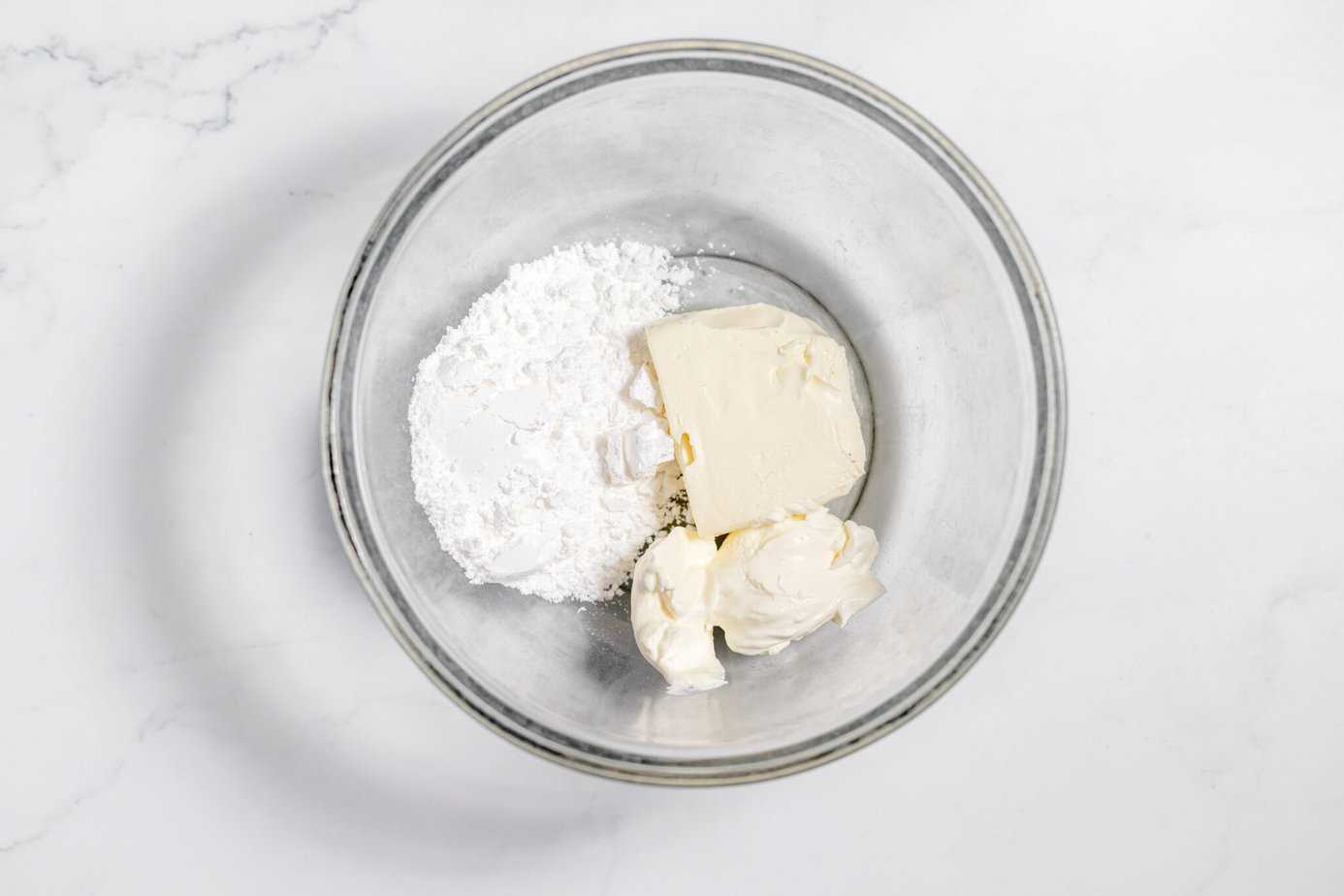cream cheese, sour cream and powdered sugar in a bowl