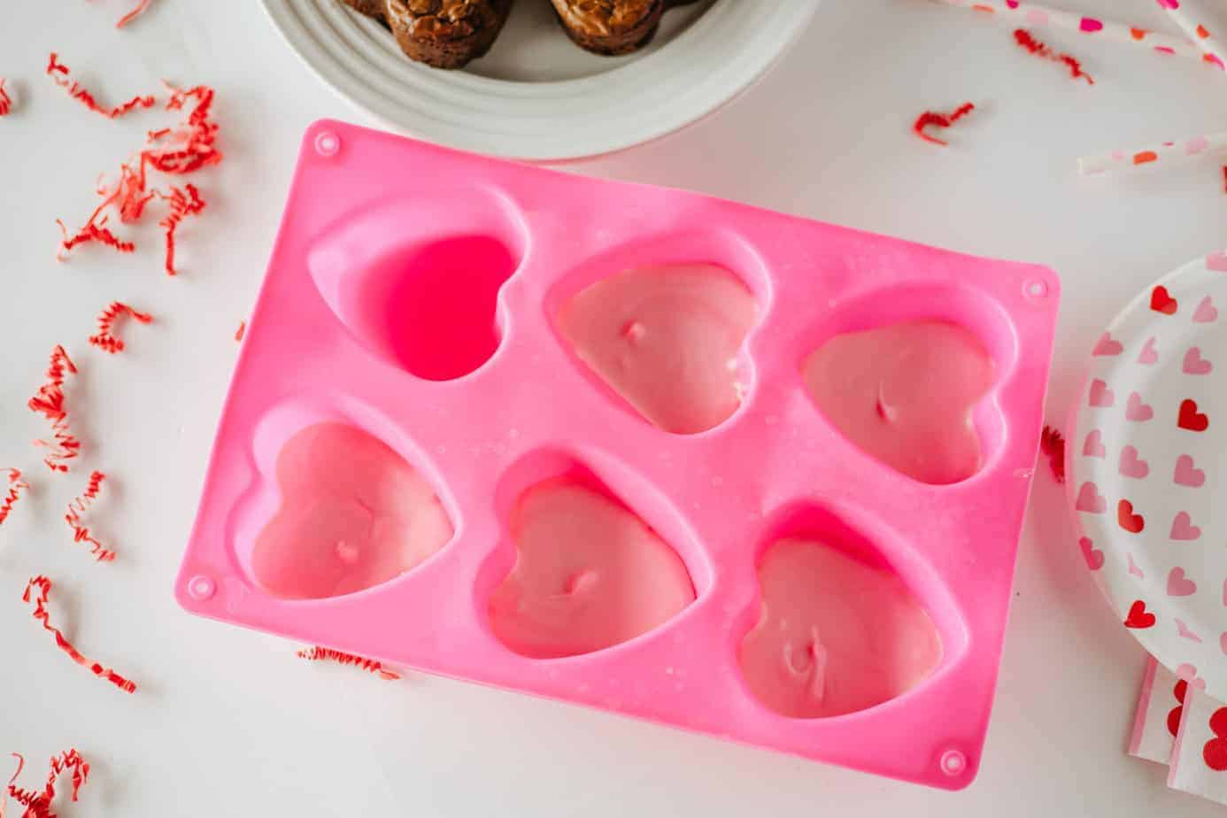 pink chocolate in heart shaped silicone molds