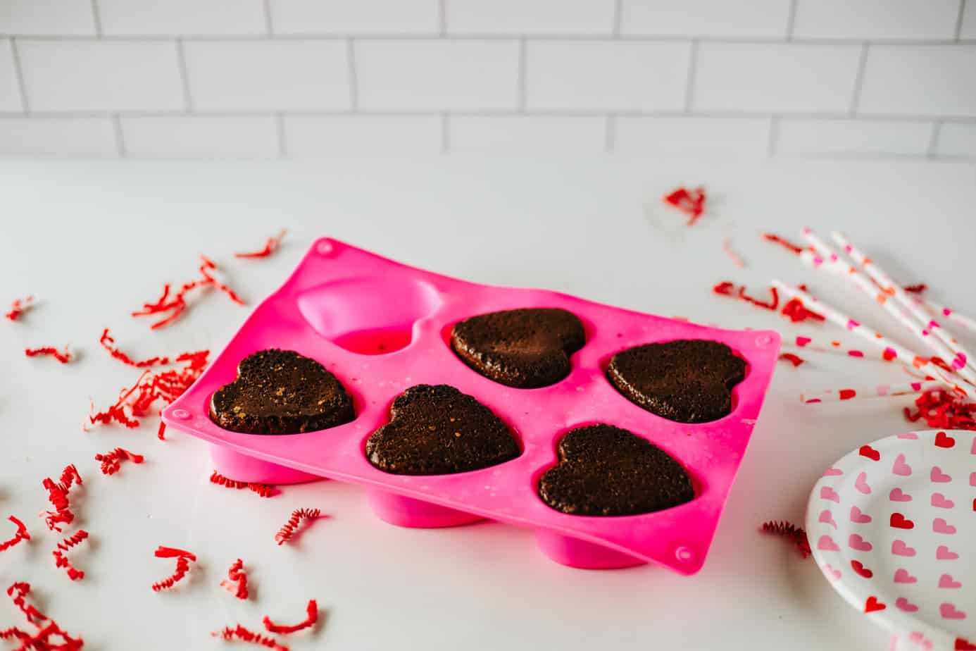 brownies added back to silicone molds on top of melted chocolate