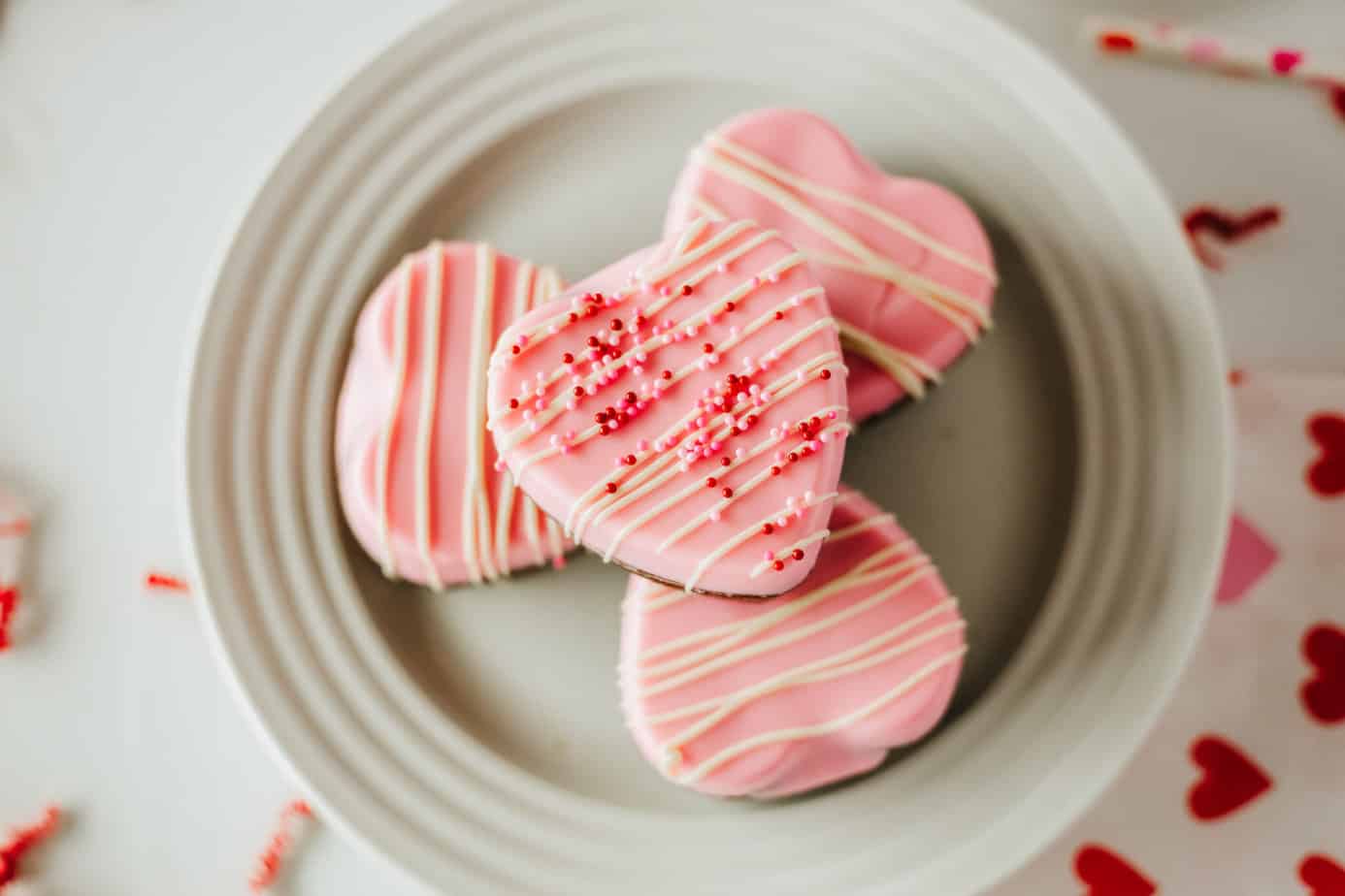 Perfect Valentine Brownies stacked on a white plate with pink frosting