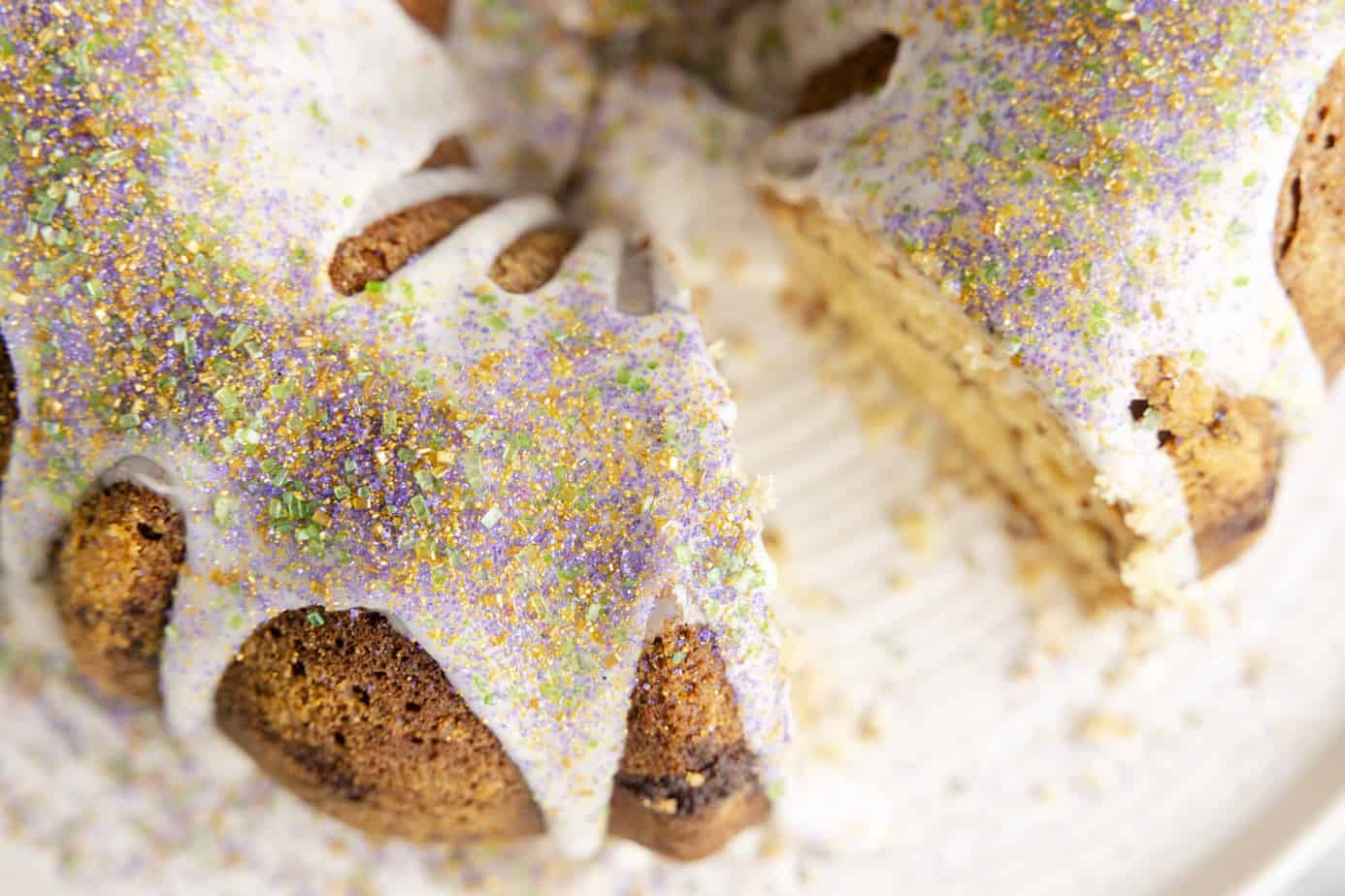 Cinnamon Bundt Cake on a white cake stand with a slice missing