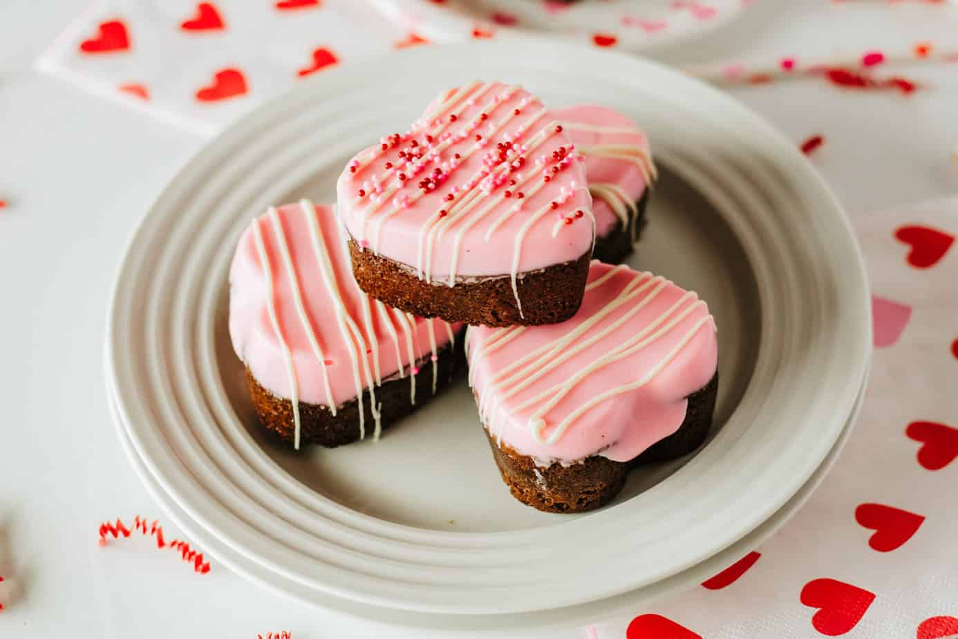 A stack of valentine's day cookies. pink frosting on top