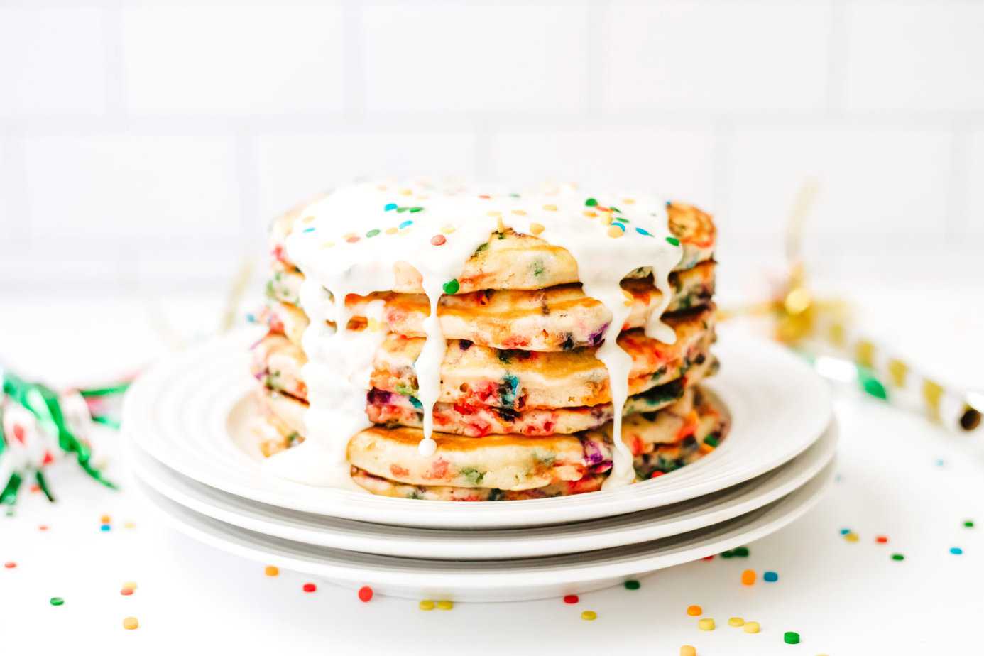 stack of funfetti pancakes with white icing poured over top