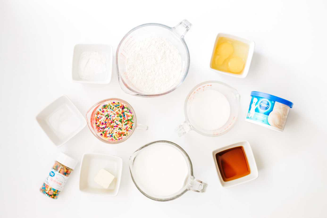 funfetti pancakes ingredients on a white surface in individual bowls