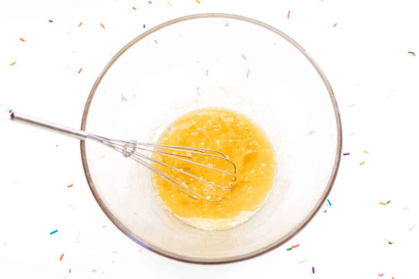 wet ingredients whisked in clear glass bowl