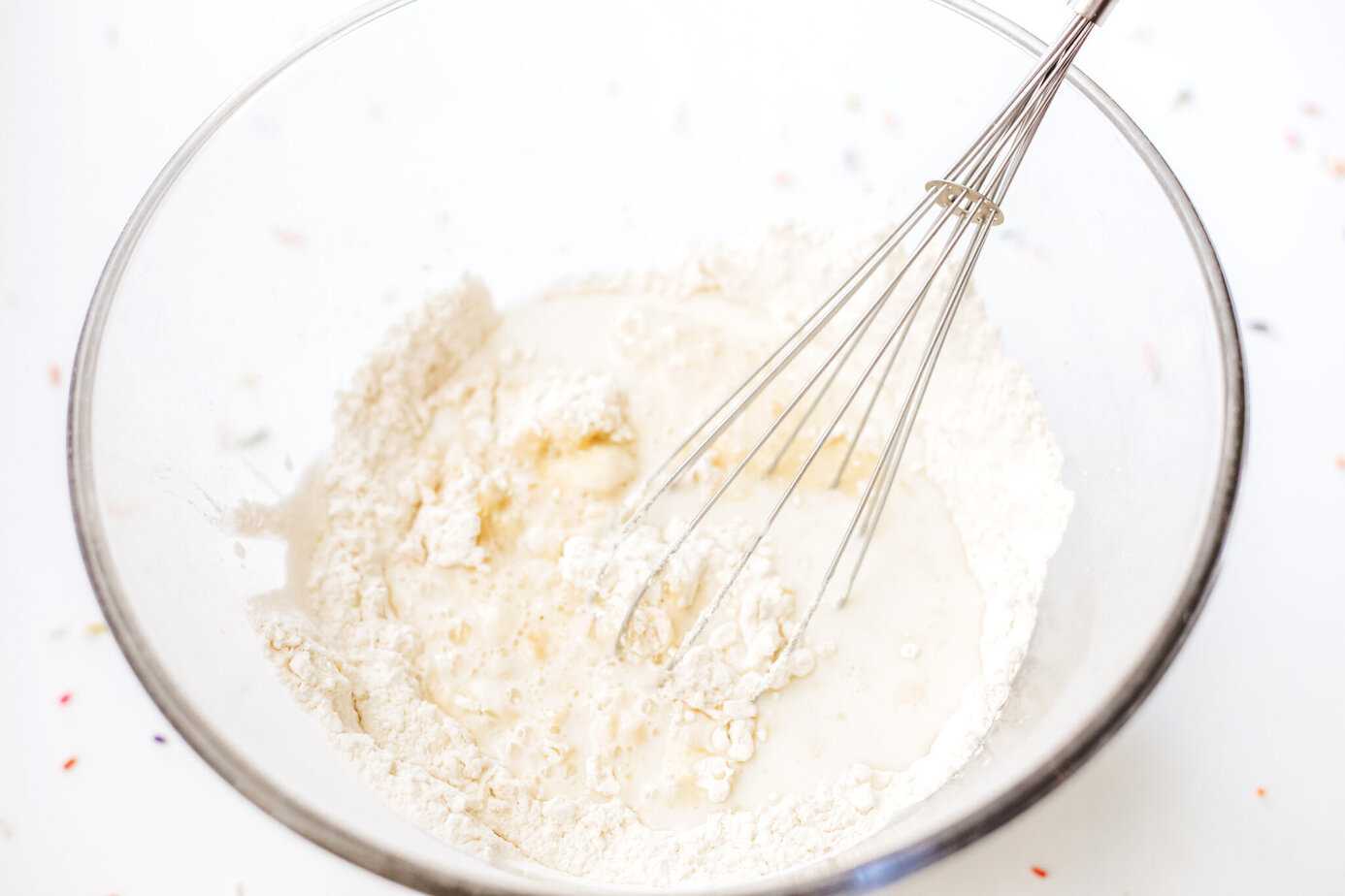 dry ingredients sifted into clear glass bowl with wet ingredients