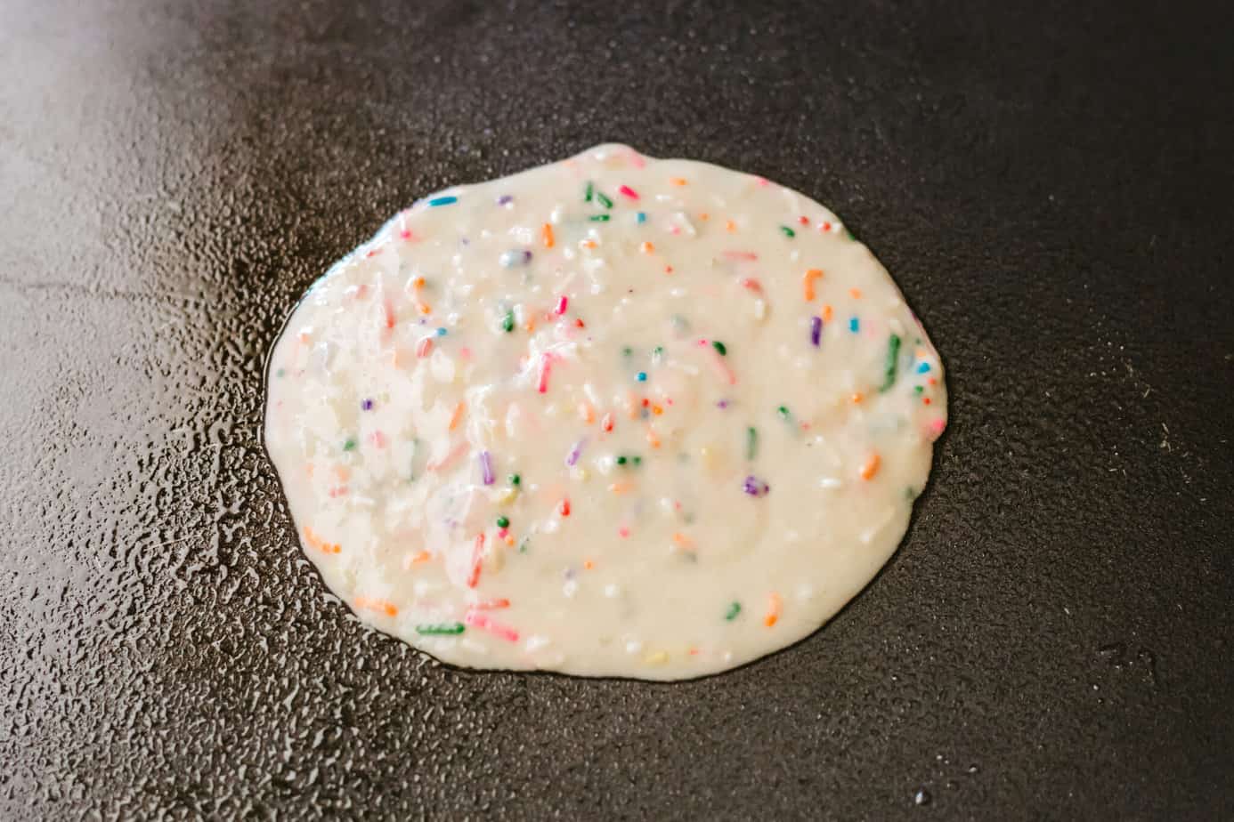 funfetti pancake batter on a hot griddle