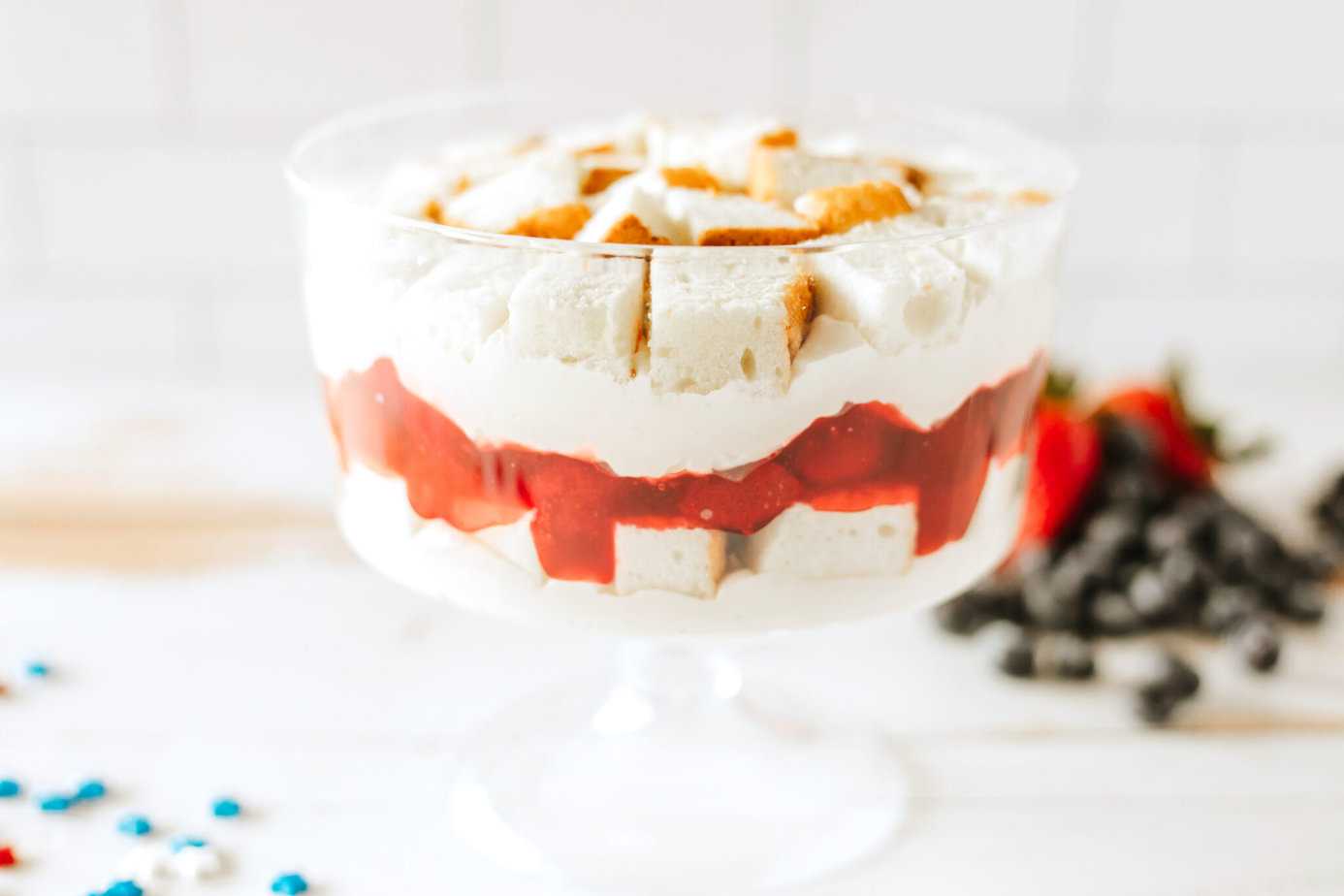 layers of pudding mixture with angel food cake and strawberries in trifle dish