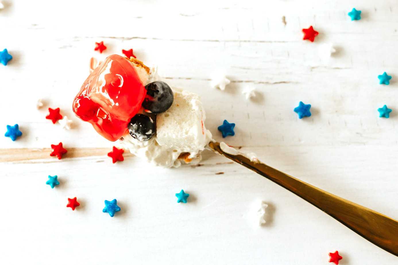 a bite of red white and blue trifle on a gold fork