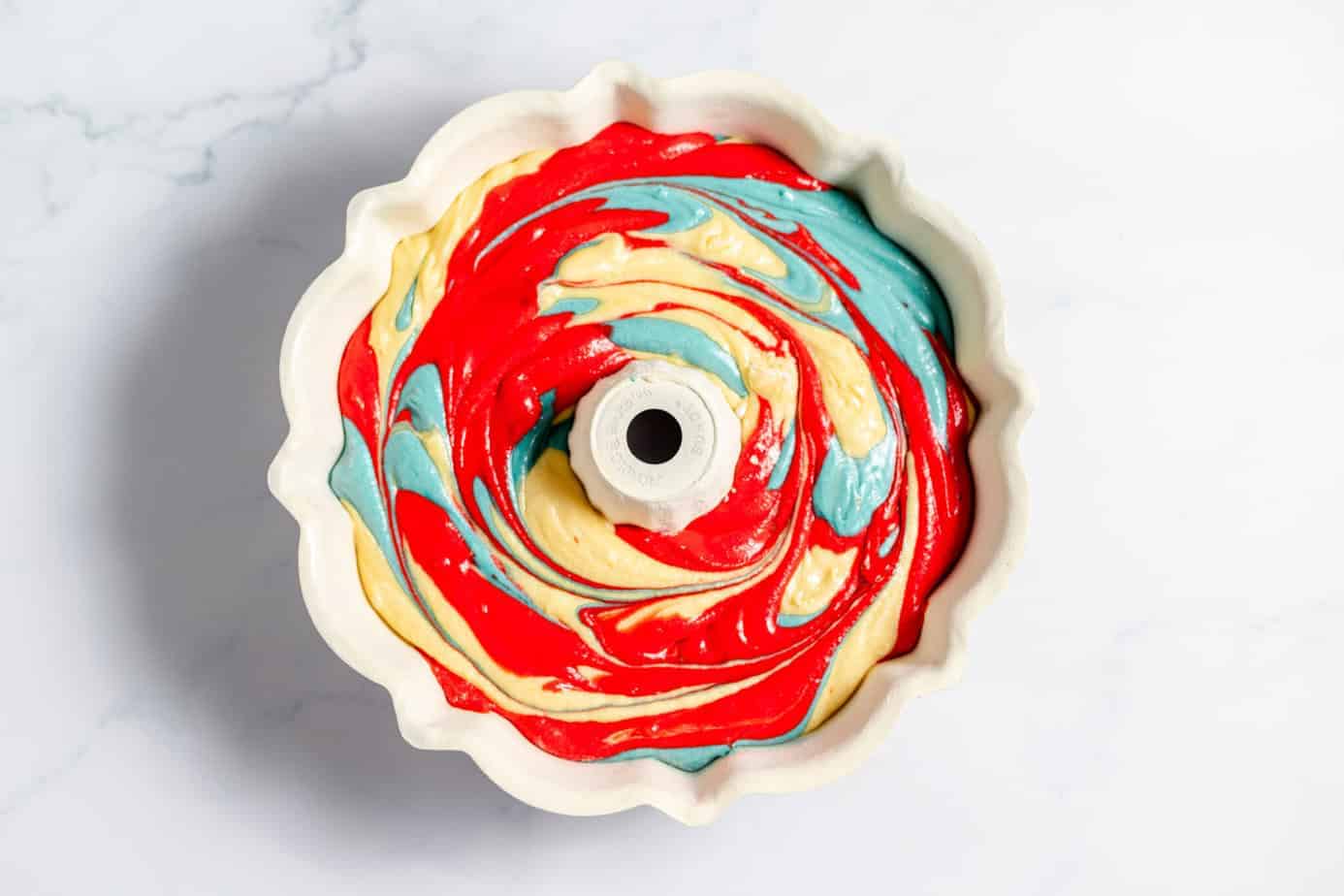 red white and blue cake batter swirled in bundt pan