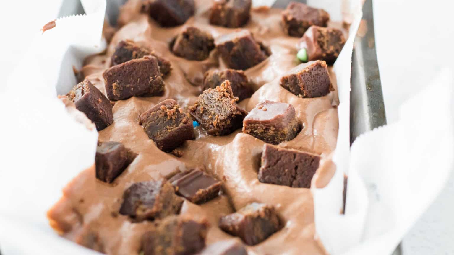 Little Debbie Cosmic Brownie Ice Cream in loaf pan lined with parchment paper and topped with cosmic brownies