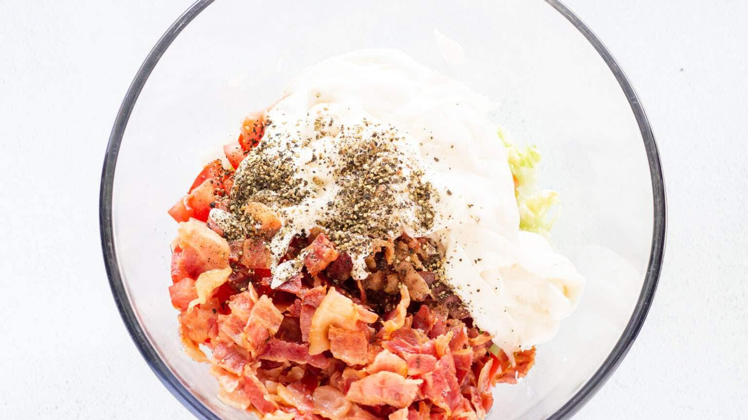 bacon lettuce and tomato in bowl with sour cream and mayo on top plus salt and pepper