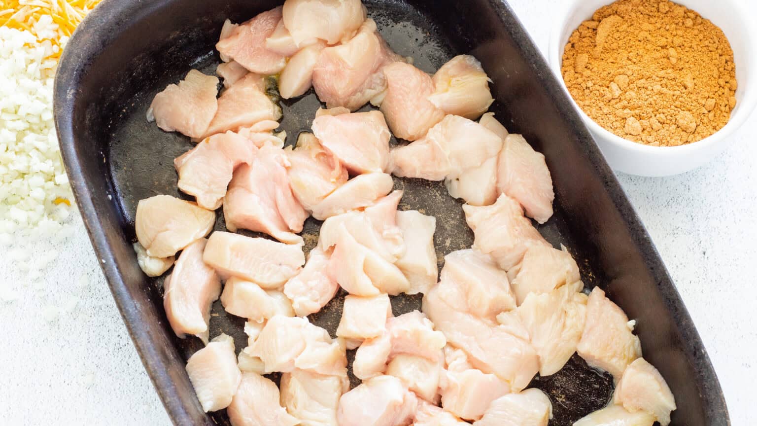 diced chicken in black casserole dish