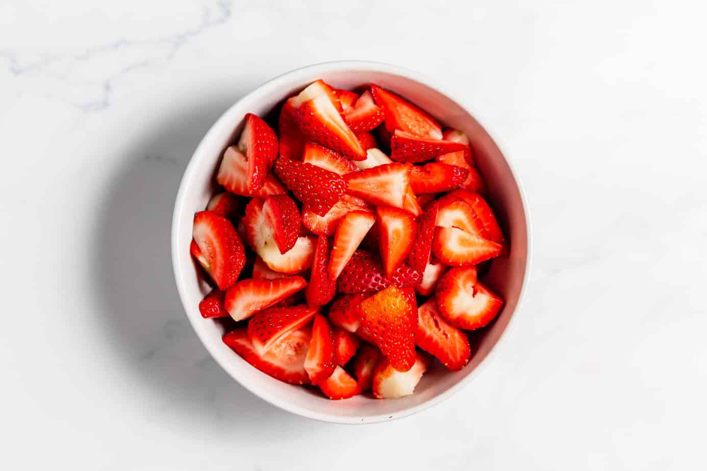 Chopped strawberries in a white bowl