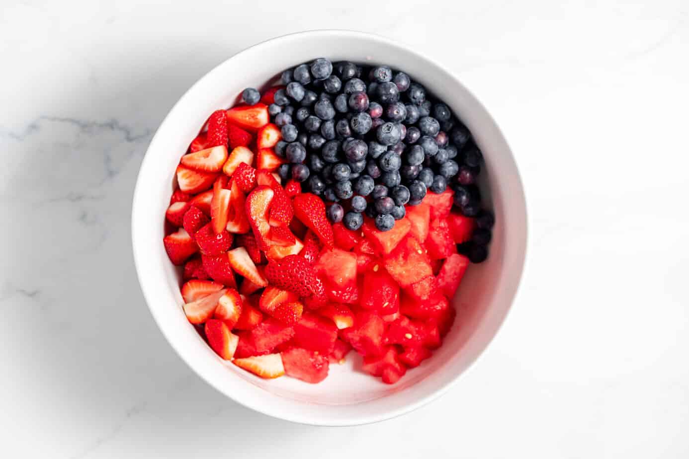Blueberries, watermelon, and strawberries in a white bowl