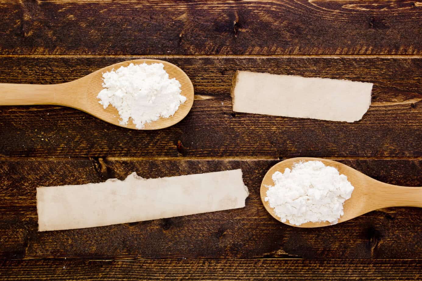 baking powder and baking soda on wooden spoons on wooden surface
