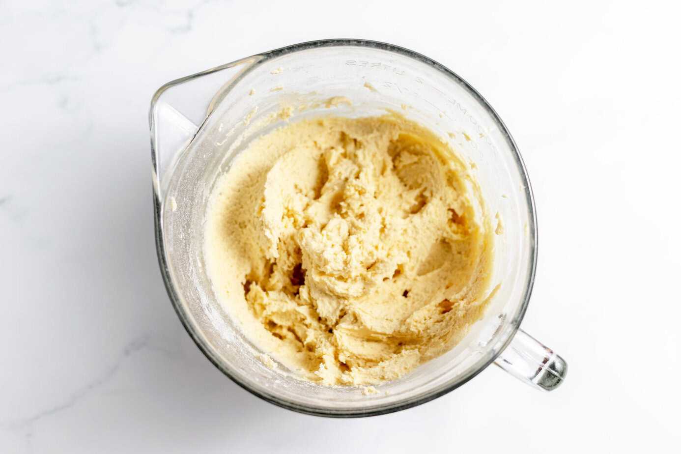 mixed up cookie dough in clear glass bowl