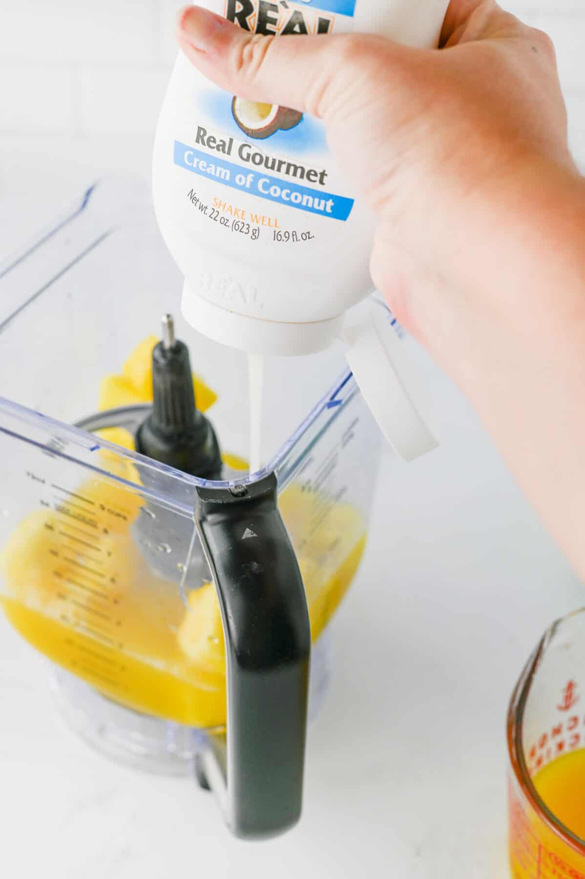 adding cream of coconut to blender
