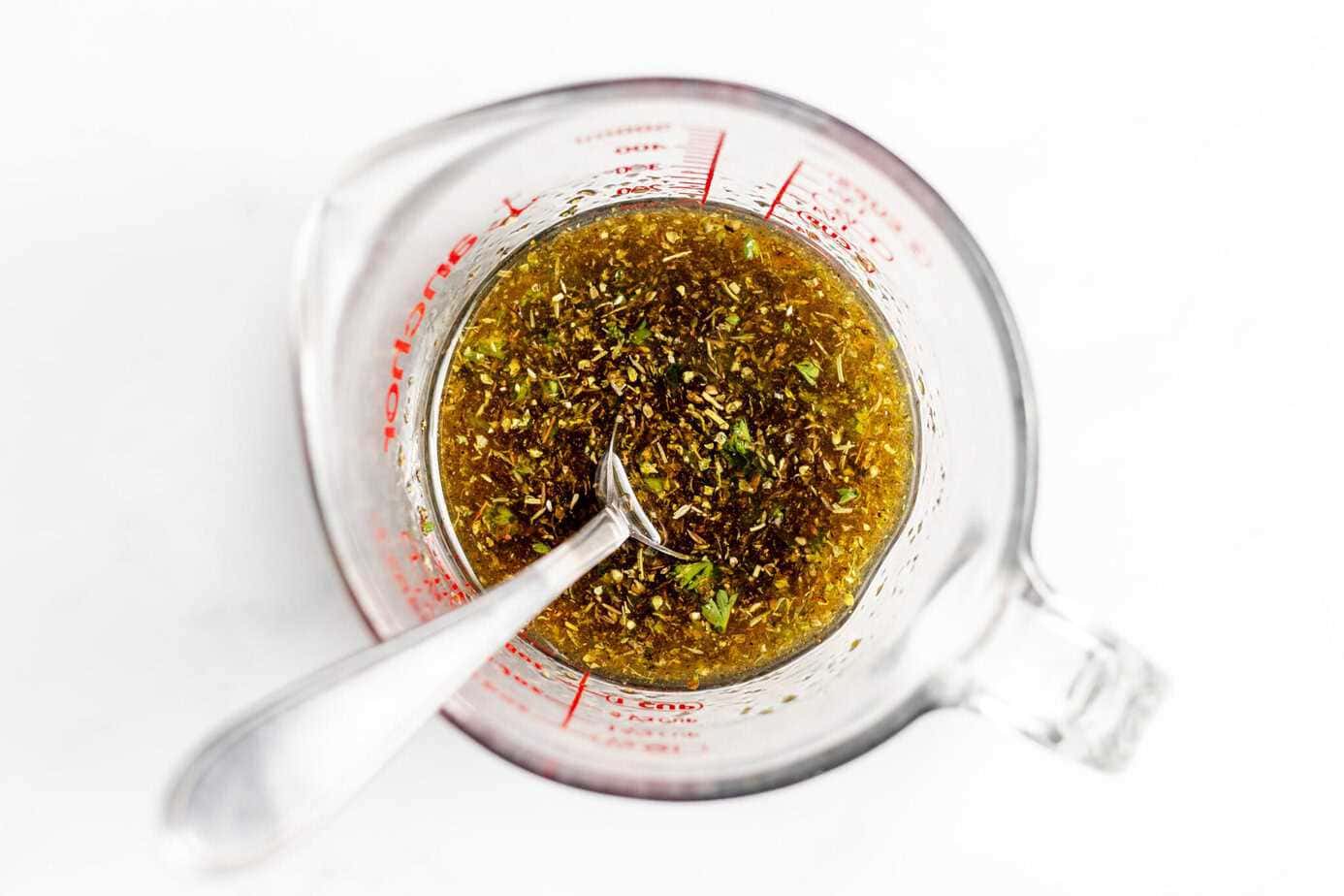 chicken marinade ingredients in glass measuring cup mixed up