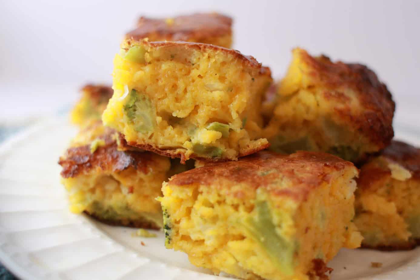 cheesy broccoli bread cut into squares stacked on a plate